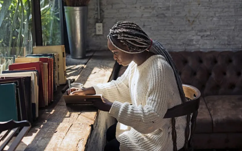 a woman journals at her desk